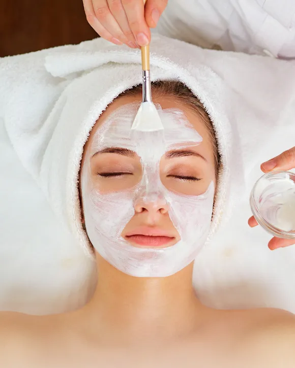 Facial treatment in progress, mask applied with a brush, at a spa treatment room